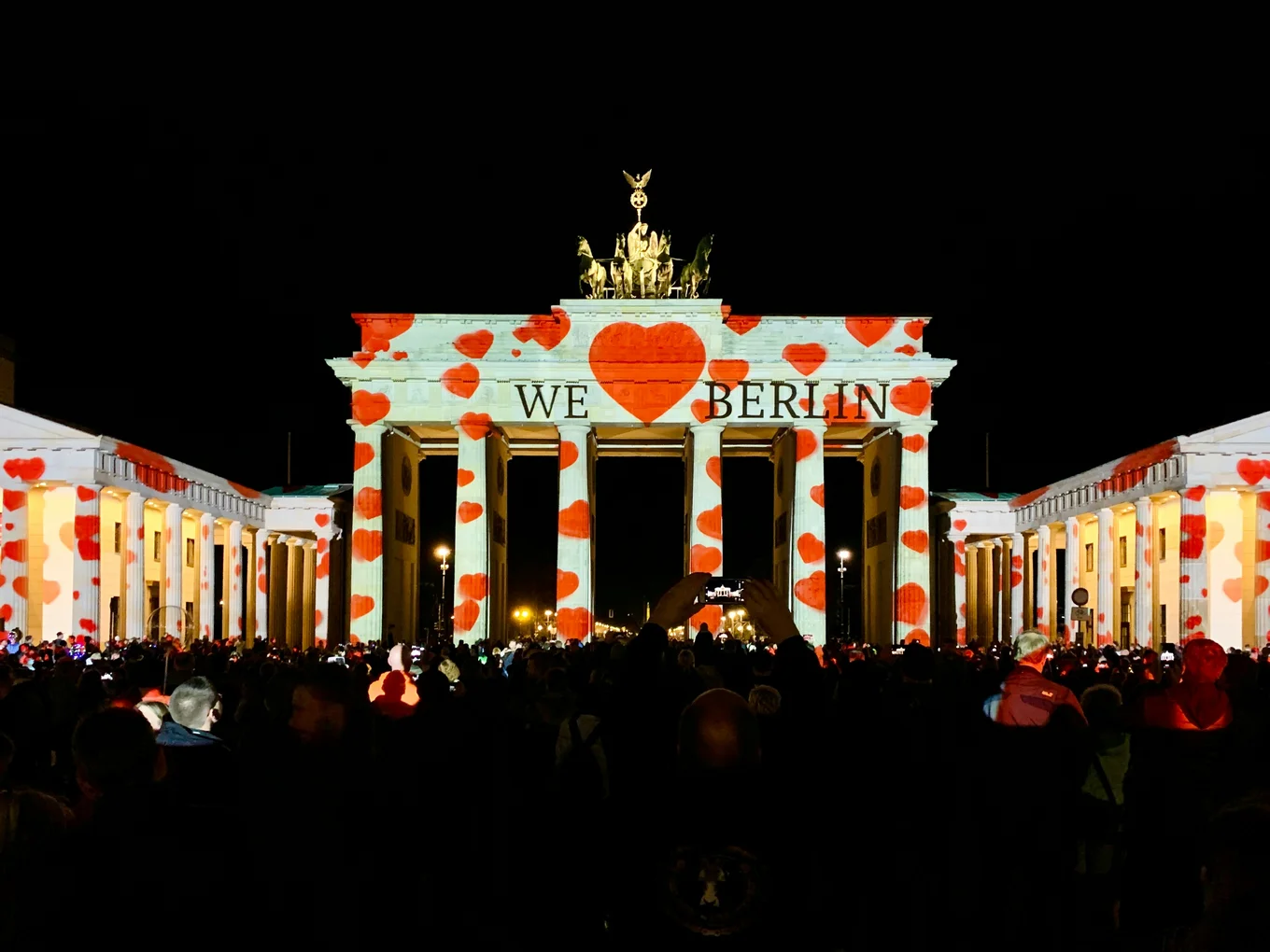 the Brandenburg gate in Berlin at night, lit up with hearts by a projector and "I heart Berlin" written on it