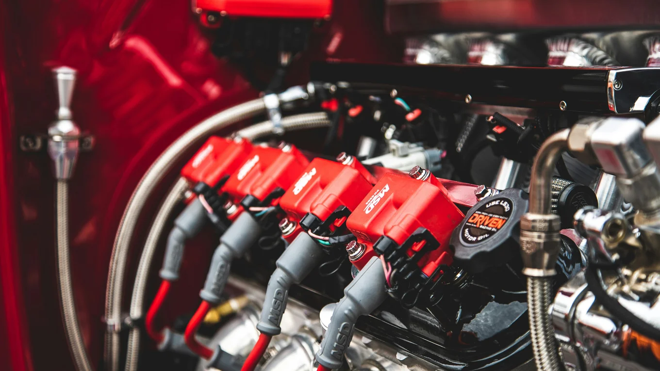 Red engine components with cables and hoses.